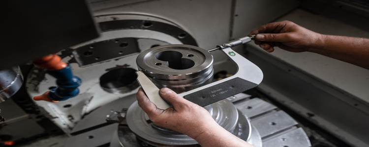 A rubicon employee checks the dimensional accuracy of a milled machine component.